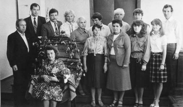 Talsu rajona tautas tiesas kancelejas vadītājas Veriņas jubilejā 1985. gada 15. augustā. Līdzās tiesas sēžu sekretārēm Vinetai un Agitai, tiesu izpildītājām Lilitai, Vilmai un Rutai un mašīnrakstītājai Ainai kupli pārstāvēta arī advokātu saime: ne vien Talsos rezidējošie Ingrīda Kalniņa un Ģirts Ozoliņš, bet arī Dzintra Zālīte, Solveiga Ozoliņa un Gunārs Priede. Kreisajā pusē – tautas piesēdētāju padomes priekšsēdētājs Jānis Melderis